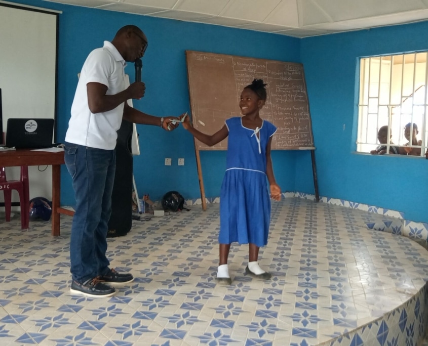 The team lead rewarding one of the children for excelent performance.